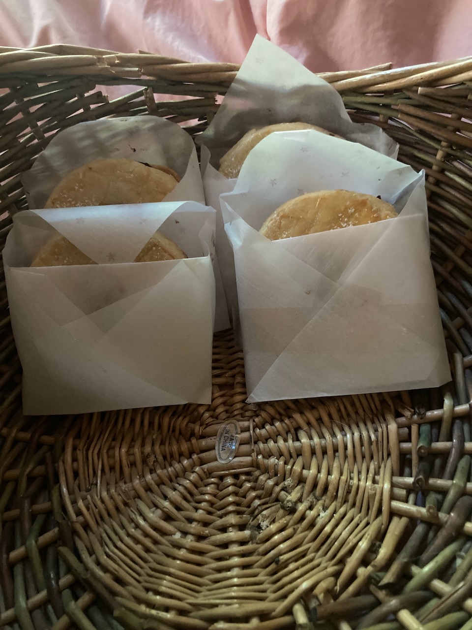 A basket with a stack of Dorian cookies in wax paper wrappers