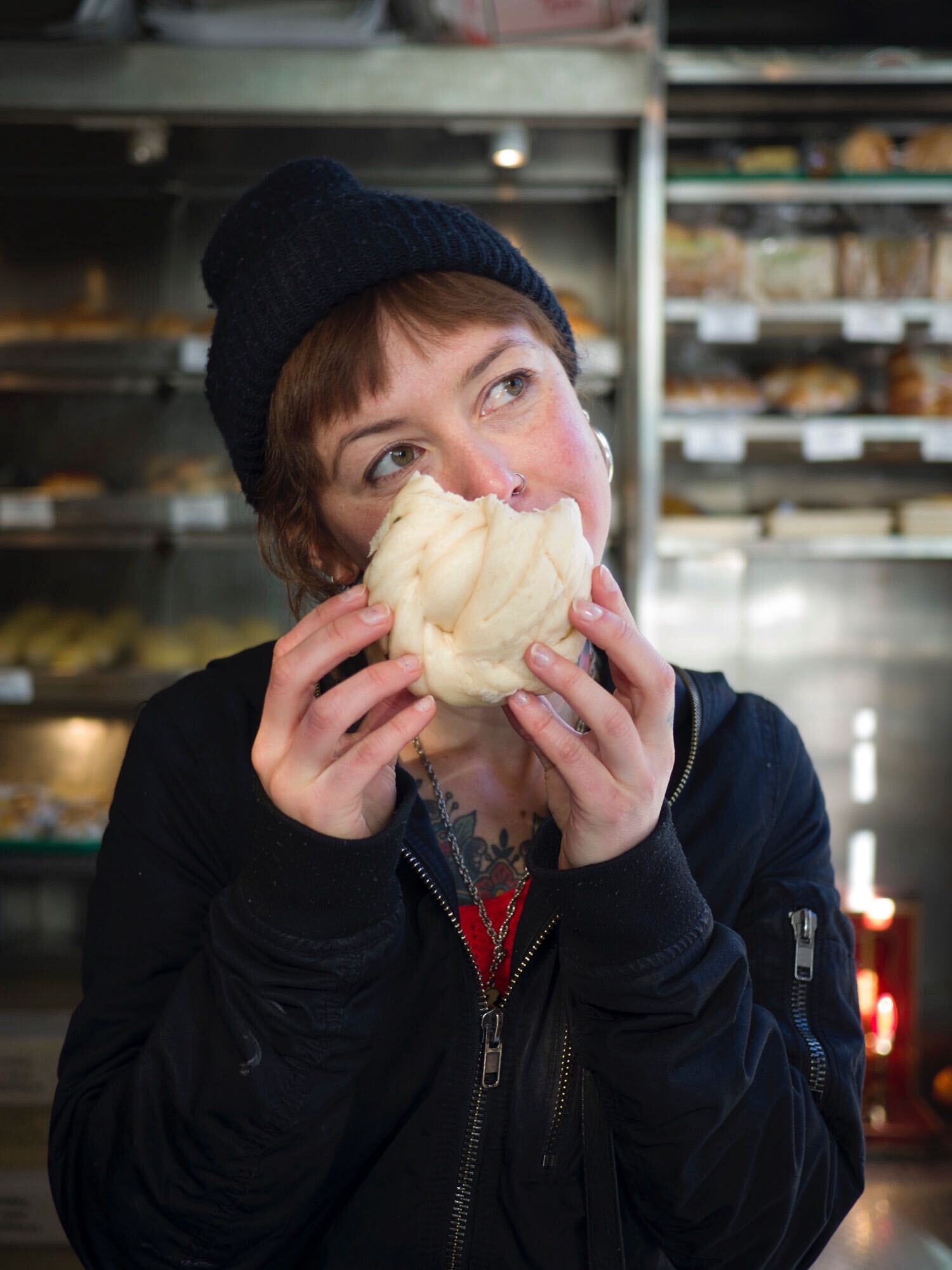 Martha eats a doughy bun in shop in Chinatown in New York City